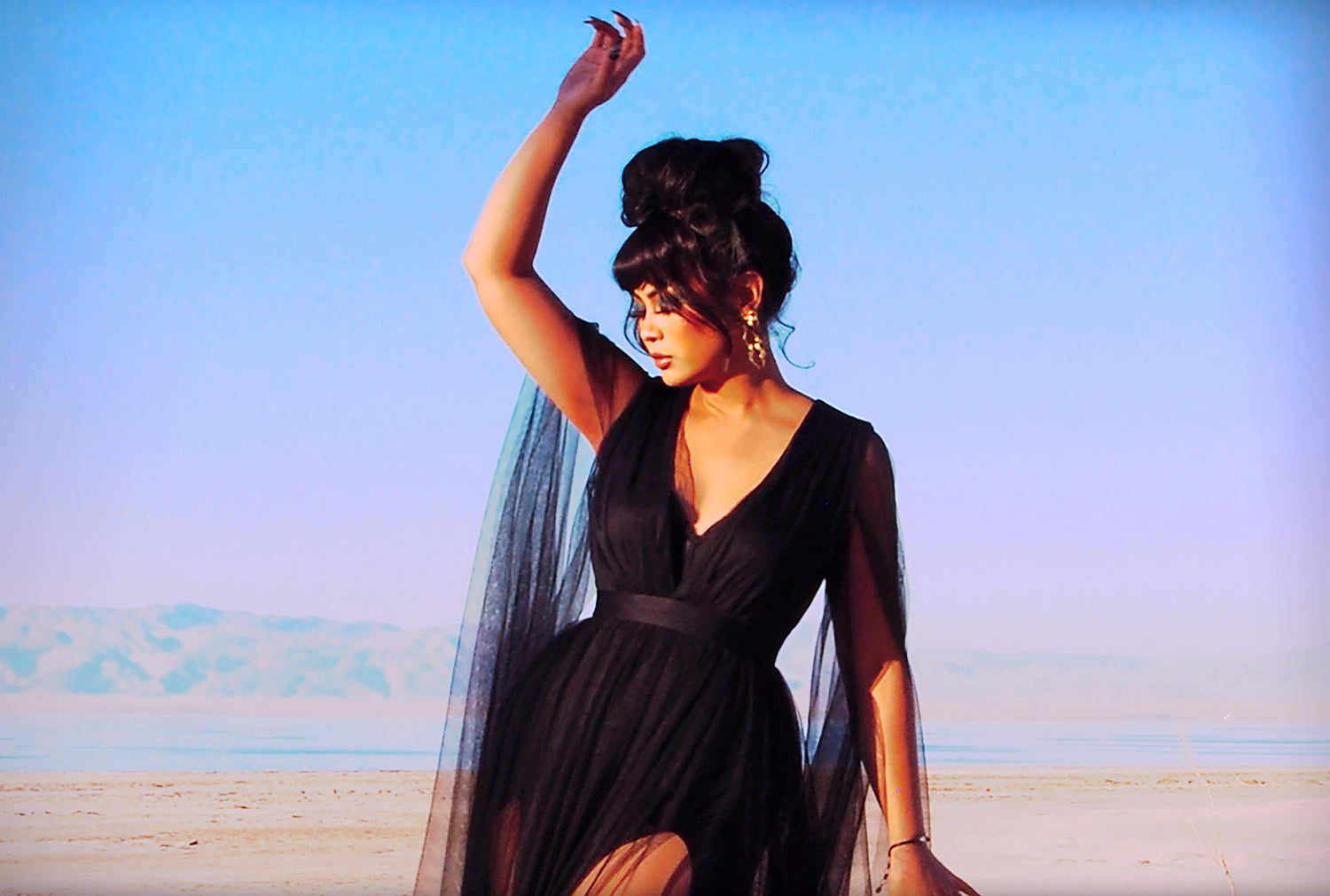 Woman in a flowy black gown in the desert